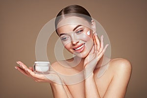 Beauty woman applying cream on her face photo