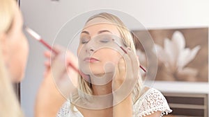 Beauty woman applying makeup. Beautiful girl looking in the mirror
