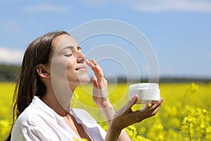 Beauty woman applying moisturizer cream on face photo