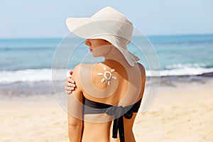 Beauty Woman applying Sun cream on tanned shoulder. Skin and Body care. Sun protection.
