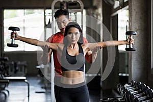 beauty woman bicep train with coach in gym