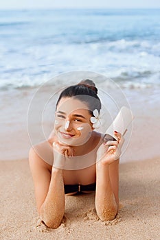 Beauty Woman in Bikini Holding Bottles of Sunscreen in Her Hands. Skincare. A Beautiful Female Applying Sun Cream.