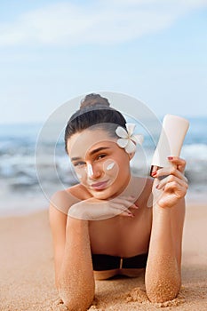 Beauty Woman in Bikini Holding Bottles of Sunscreen in Her Hands. Skincare. A Beautiful Female Applying Sun Cream.