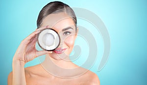 Beauty woman with coconut. Pretty young brunette girl holding coco nut and smiling. Spa and skincare