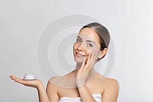 Beauty Woman Concept. Skin care. Young model with Soft skin holding cosmetic cream. Nude make-up.