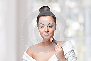 Beauty woman contouring with a makeup brush