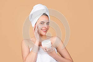 Beauty woman with cosmetic products clean healthy natural skin. Portrait of attractive young girl with a bath towel on