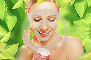 Beauty woman with cream and natural skin care in green