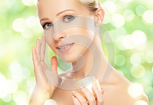 Beauty woman with cream and natural skin care in green