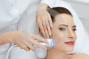 Beauty. Woman Doing Blue Light Facial Treatment On Face Skin