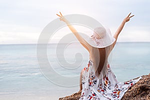 Beauty woman doing cheerful gesture beside the beach. Woman raise two hands and breathing fresh air happily. People and Lifestyles
