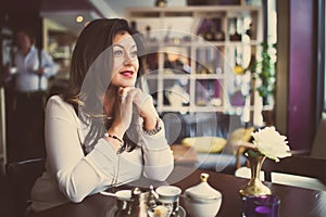 Beauty woman enjoying drink after work.Beautiful smiling middle aged woman sitting alone in cafe