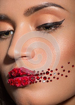 beauty woman face with creative make up red lips, roses and rhinestone