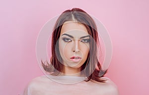 Beauty woman face on pink background. Hairstyle styling. Fashion, beauty, cosmetics. Perfect makeup, smooth skin