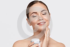 Beauty Woman face Portrait. Beautiful Spa model Girl with Perfect Fresh Clean Skin. Holdinging and apply moisturizing cream. Skin