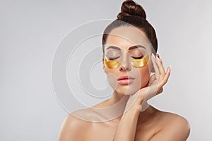 Beauty woman face with under eye collagen gold pads. Anti-aging moisturizing eye mask, golden hydrogel patches