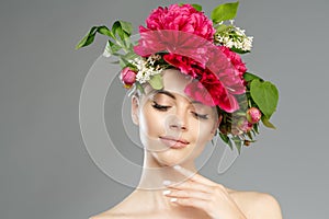 Beauty woman with flowers on head. Happy beautiful girl on gray banner background. Pretty model with clear skin. Spring fashion