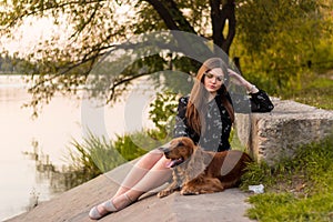 Beauty woman with her dog playing outdoors