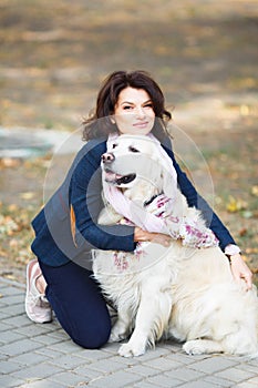 Beauty woman with her dog playing outdoors. Woman walking Labrador Retriever in park