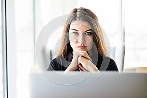 Beauty woman with laptop in front look at camera in office