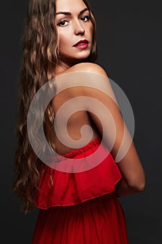 Beauty woman with long curly hair.Beautiful girl in red dress