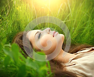 Beauty woman lying on the field and dreaming