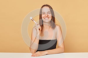 Beauty woman with makeup brushes. Make up for woman. Female model applying blush powder foundation tone. wearing black top