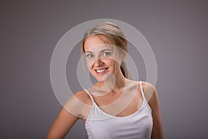 Beauty of woman with no make up on gray background in studio photo. Fresh clean look. Healthy skin