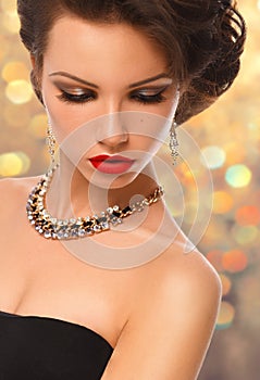 Beauty Woman with Perfect Makeup and luxury accessories on gold background