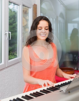 Beauty woman playing piano at home