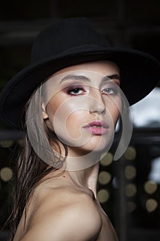 Beauty woman portrait. Beautiful model girl with makeup, bare shoulders. Youth and skin care concept. Black background.