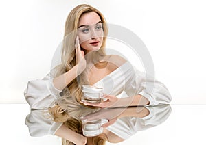 Beauty woman portrait with curly blonde hair with cosmetic cream. Skin care concept