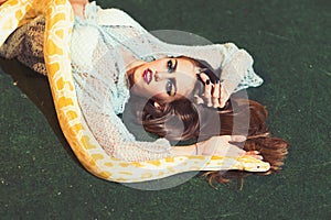 Beauty woman relax with albino python. Beauty model with makeup face and yellow snake.