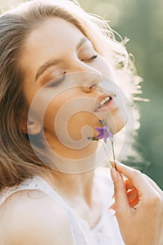 Beauty of a Woman`s Face with healthy skin and a green plant. Female portrait at sunset.