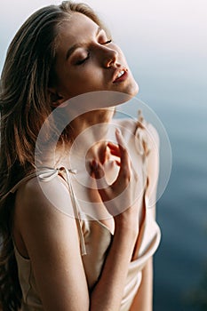 Beauty of a Woman`s Face with healthy skin and a green plant. Female portrait at sunset.