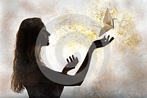 Beauty woman silhouette with flying paper crane