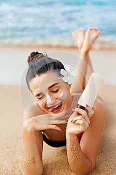Beauty Woman Skin care sunscreen  holding bottles in her hands. Suntan Girl applying sun cream on face.