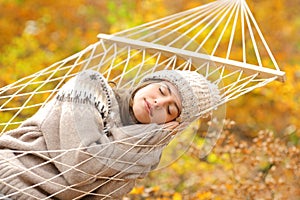 Beauty woman sleeping on hammock in a forest in fall season