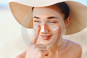 Beauty Woman smile applying sun cream on face. Skincare. Body Sun protection.