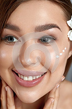 Beauty woman about to apply face cream. Holding Moisturizing Lotion.