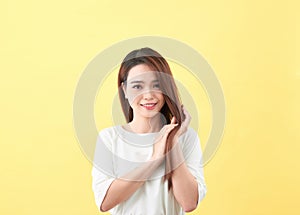 Beauty woman touch her long hair isolated on yellow background, asian beauty