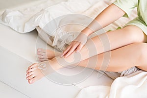 Beauty women`s legs with smooth skin in the home interior, foot care and depilation concept