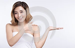 Beauty young asian woman pointing hand for product on white background. treatment & Skin care concept