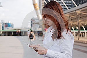 Beauty young Asian woman using mobile smart phone at urban background. City life concept.