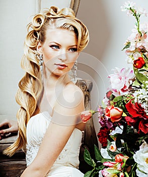 Beauty young blond woman bride alone in luxury vintage interior with a lot of flowers