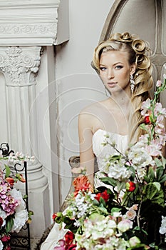 Beauty young bride alone in luxury vintage interior with a lot of flowers close up