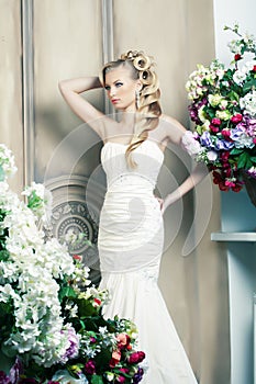 Beauty young bride alone in luxury vintage interior with a lot of flowers, makeup and creative hairstyle