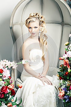 Beauty young bride alone in luxury vintage interior with a lot of flowers, makeup and creative hairstyle