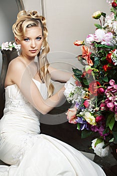 Beauty young bride alone in luxury vintage interior with a lot of flowers, makeup and creative hairstyle