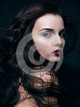 Beauty young brunette woman with curly flying hair